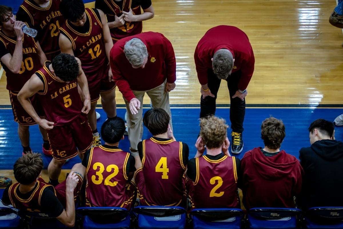 An illustration of players working together, deploying tactical strategies to control map areas, with camo designs highlighted on weaponry in the foreground.